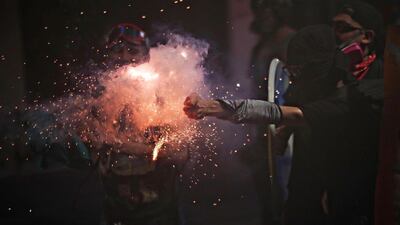 A demonstrator throws fireworks at security forces during a protest against Chile's government in Santiago, Chile. Reuters