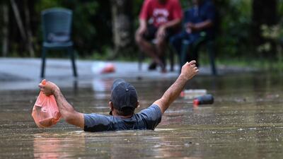 A man carries foods through floodwaters in Lanchang in Malaysia's Pahang, AFP