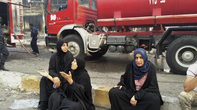 Iraqi women wait for their family members who are missing after a car bomb in the Karada neighbourhood. Khalid Mohammed/AP Photo