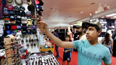 Nawaf Al Blooshi checks out accessories at the Eid fair in Fujairah. Victor Besa for The National