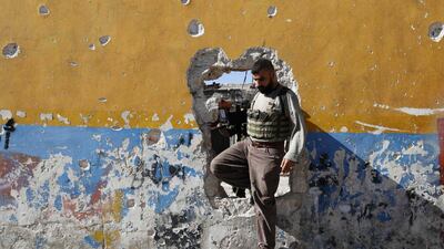 A rebel fighter walks through a hole in a wall on the frontline of Ramouseh, an area located beside Aleppo Artillery school. Hosam Katan / Reuters