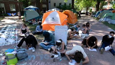 Students write letters in support of Palestinians in Gaza at an encampment at George Washington University, in Washington. AP