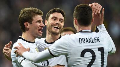 Germany's defender Jonas Hector celebrates scoring the 3-0, his first goal for Germany with Germany's midfielder Thomas Mueller (L) and Germany's midfielder Julian Draxler (R) celebrate after the third goal during the friendly football match Germany vs Italy in Muinch, southern Germany, on March 29, 2016. AFP / CHRISTOF STACHE