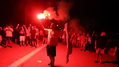 A pro-Palestinian supporter holds a flare during a protest against what is said to be a second attack. EPA