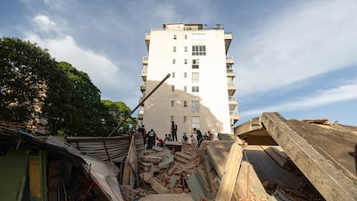 Rescue workers gather at the site of a collapsed building in the capital Caracas. EPA