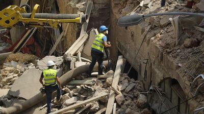 Rescue workers prepare to use a tube to vacuum debris from a badly damaged building in Lebanon's capital Beirut, in search of possible survivors from a mega-blast at the adjacent port one month ago, after scanners detected a pulse. Lebanese rescuers scoured rubble for a possible survivor in Beirut after the detection of a pulse drew crowds hopeful of a miracle one month on from a devastating explosion. AFP
