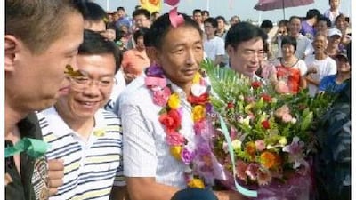 Zhan Qixiong, the Chinese trawler captain, with flowers, returns to his hometown in Jinjiang city on Monday. Reuters