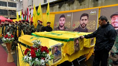 Hezbollah members stand next to coffins during a funeral in a southern suburb of Beirut, Lebanon. EPA