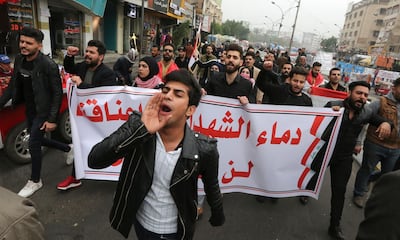 Iraqi protesters carry a banner which reads "The blood of martyrs is entrusted to us, it will not be in vain" during a march in Tahrir Square in the capital Baghdad, amid ongoing anti-government demonstrations, on December 7, 2019. / AFP / SABAH ARAR