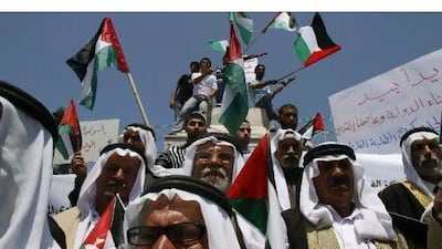 Palestinians wave the national flag during a rally to support the political unity deal between the Hamas movement, which rules in the Gaza Strip, and its West Bank rival party Fatah, in Gaza City yesterday.