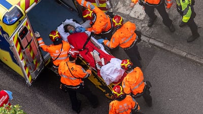 Health workers evacuate a woman. AP