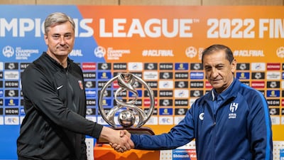 Urawa Reds Diamonds head coach Maciej Skorza, left, and Al Hilal manager Ramon Diaz shake hands in front of the Asian Champions League tropy ahead of the final second leg in Saitama, Japan. AFP