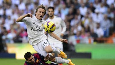 Barcelona's Lionel Messi tackles Real Madrid's Luka Modric during Saturday's 'El Clasico' in Madrid, which Real won 3-1. Dani Pozo / AFP