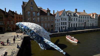 A boat of tourists sails past the installation depicting a whale, made up of five tons of plastic waste pulled out of the Pacific Ocean. John Thys / AFP