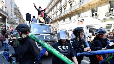 Paris protesters in helmets march during La Fete a Macron to protest policies of President Emmanuel Macron. Gerard Julien / AFP