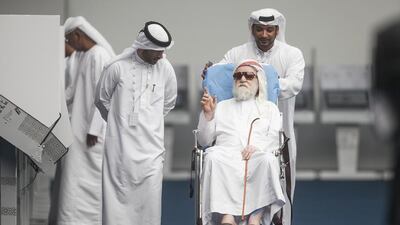 A senior citizen being helped at the polling station in Al Ain. Mona Al Marzooqi/ The National