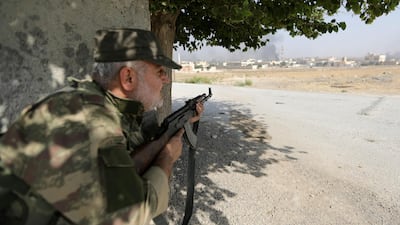 Smoke rises as a Turkey-backed Syrian rebel fighter takes cover in the town of Tal Abyad, Syria. REUTERS