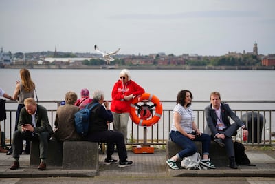 People take a break during lunchtime on the Mersey river shore, at the Labour Party conference in Liverpool, on Tuesday. AP Photo