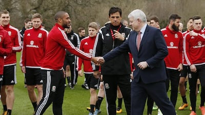 Wales’ Ashley Williams shakes hands with First Minister of Wales Carwyn Jones as manager Chris Coleman and team mates look on during training. Reuters / Andrew Boyers