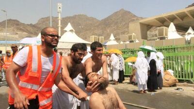 Saudi emergency personnel and pilgrims help a man injured in the stampede in Mina, near the holy city of Mecca in Saudi Arabia. AFP Photo