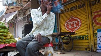 A banana seller smokes a bidi, the ‘poor man’s cigarette’.