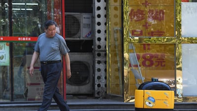 A man looks at a Zhen Robotics 'little yellow horse' delivery robot in Beijing. AFP