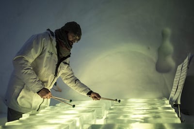A musician performs with an ice xylophone during a concert in the "Ice Dome". AFP