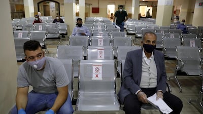 People wearing protective face masks wait to complete their transactions in the Civil Status Department after Jordan's public sector employees returned gradually to work. Reuters
