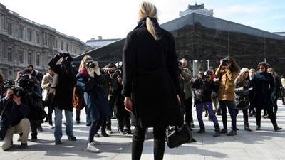 Photographers greet arrivals for Louis Vuitton's Fashion Week show in central Paris.