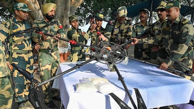 Members of India's Border Security Force show the drone and packets of suspected heroin brought down near Amritsar on November 29. AFP