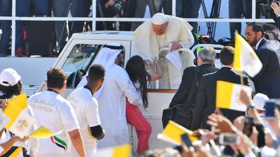 Pope Francis blesses a young girl as he arrives to lead mass for an estimated 150,000 Catholics in Abu Dhabi this week. Vincenzo Pinto / AFP