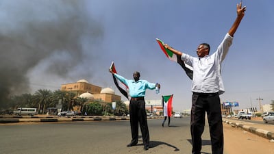 Sudanese men wave national flags as protesters take to the streets of the capital Khartoum to demand a transition to civilian rule.