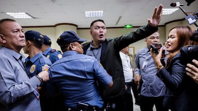 Security guards and police officers urge members of the media to stay back after gunshots were heard at the Philippine Senate in Manila, where Senator Ronald dela Rosa, wanted by the International Criminal Court, had taken refuge. Reuters