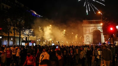 Paris Saint-Germain supporters walk on the Champs-Elysees and set off fireworks in Paris. AFP