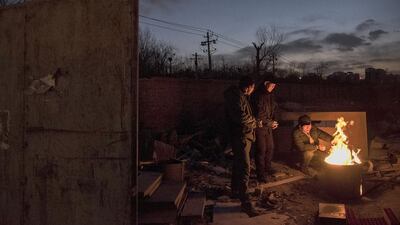 Chinese labourers stay warm on a fire as they wait for goods to be recycled in the Dong Xiao Kou village. Kevin Frayer / Getty Images