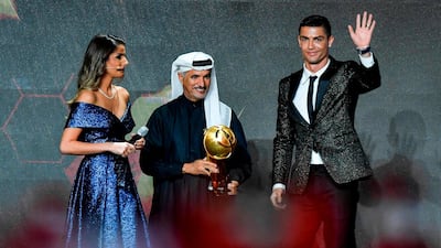 Juventus' Portuguese forward Cristiano Ronaldo (R) waves before receiving from Secretary General of Dubai Sports Council (DSC), Saeed Mohammed Hareb (C) the 433 Fans' Award during the 10th edition of the Dubai Globe Soccer Awards in Dubai. AFP
