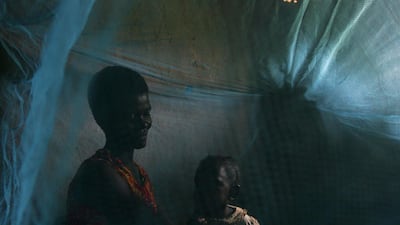 A mother and her children prepare for bed in Kisumu, Kenya. They use a donated repellent-impregnated mosquito net to protect themselves. Getty