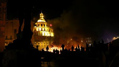 Protesters stand near burning tents during anti-government protests in Beirut. Reuters