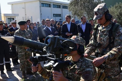 France's President Emmanuel Macron, Cyprus's President Nikos Christodoulides and Greece's Prime Minister Kyriakos Mitsotakis watch a rocket being aimed. AFP