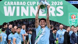 TOPSHOT - Manchester City's English midfielder #33 Nico O'Reilly poses with the trophy as City players celebrate after the English League Cup final football match between Arsenal and Manchester City at Wembley Stadium in London on March 22, 2026. Nico O'Reilly scored both goals as City won the game 2-0. (Photo by Adrian DENNIS / AFP) / RESTRICTED TO EDITORIAL USE. No use with unauthorized audio, video, data, fixture lists, club/league logos or 'live' services. Online in-match use limited to 120 images. An additional 40 images may be used in extra time. No video emulation. Social media in-match use limited to 120 images. An additional 40 images may be used in extra time. No use in betting publications, games or single club/league/player publications. /