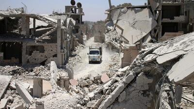 A truck drives down a destroyed street in a rebel-held area in Daraa on July 19, 2017, as civilians started to return to the area following the July 9 agreement ceasefire brokered by the US, Russia and Jordan creating a de-escalation zone in Syria's southern Daraa, Quneitra and Sweida regions. Mohamad Abazeed / AFP