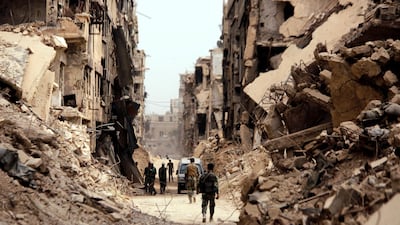 Soldiers walk past damaged buildings in Yarmouk Palestinian camp in Damascus, Syria May 22, 2018. Reuters/Omar Sanadiki