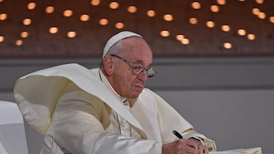 Pope Francis signs the document. AFP