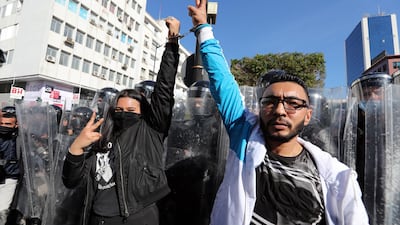 Tunisian protesters stand in front of anti-riot policemen during a demonstration in Tunis. EPA