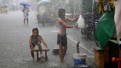 Girls play along a flooded street during heavy rains brought on by tropical storm 'Nesat' on the outskirts of Manila. Aaron Favila / AP Photo