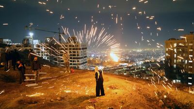 TOPSHOT - Iranians light fireworks during the Wednesday Fire feast, or Chaharshanbeh Soori, held annually on the last Wednesday eve before the Spring holiday of Nowruz, in Tehran, on March 18, 2025. The Iranian new year which begins on March 20 coincides with the first day of spring during which locals revive the Zoroastrian celebration of lighting a fire and dancing around the flame. (Photo by ATTA KENARE / AFP)