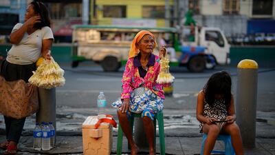 A flower seller with an ash cross on her forehead outside a church in downtown Manila, Philippines on Ash Wednesday. AP Photo