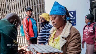 A blind woman collects her food parcel during a food distribution organised by Gift of the Givers in Johannesburg CBD, on October 14. Luca Sola / AFP