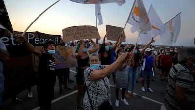 Residents of Famagusta hold Cypriot flags during a protest against a visit by Turkish President Recep Tayyip Erdogan, and the 47th anniversary of the Turkish invasion of the island, in Deryneia, Cyprus, on July 19. AP