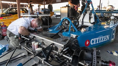 Race team members prepare the cars for two days of racing in the paddocks